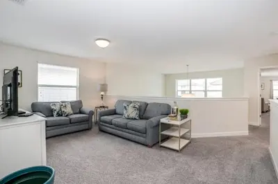 a living room with two couches and a tv at Magical Memories Await at Jimmy Cricket's Retreat in Kissimmee