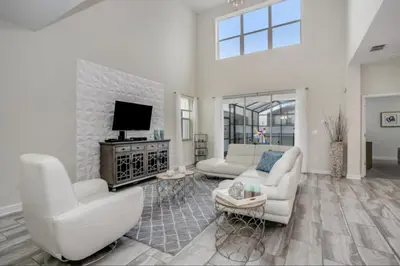a living room with white furniture and a flat screen tv at Magical Memories Await at Jimmy Cricket's Retreat in Kissimmee