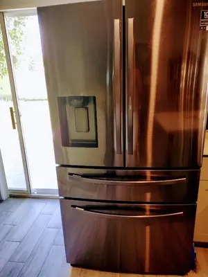 a stainless steel refrigerator in a kitchen with a window at A beautiful queen bedroom in Orlando