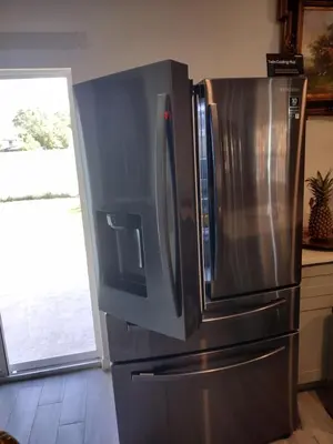 a stainless steel refrigerator in a kitchen with a window at A beautiful queen bedroom in Orlando
