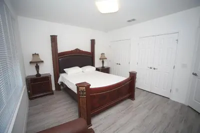 a bedroom with a large bed and two night stands at A beautiful queen bedroom in Orlando