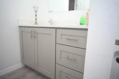 a white bathroom with a sink and a mirror at A beautiful queen bedroom in Orlando