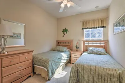 a bedroom with two beds and a dresser and a mirror at 6 Mi to WDW Family-Friendly Townhome with Foosball! in Kissimmee