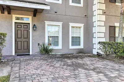a house with a brown door and a brick driveway at 6 Mi to WDW Family-Friendly Townhome with Foosball! in Kissimmee