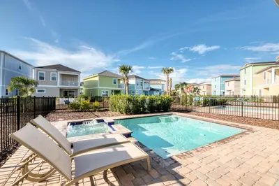 a swimming pool with a chaise lounge and a villa at Comfy Cottage Near Disney With Margaritaville Resort & Island H20 Waterpark Access - 2926Sr in Orlando