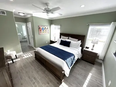 a bedroom with a large bed with blue and white sheets at Mickeys Palm - Brand New! 6BR Modern with Private Pool Hot Tub BBQ Home Theater - 2 Miles to Disney in Orlando
