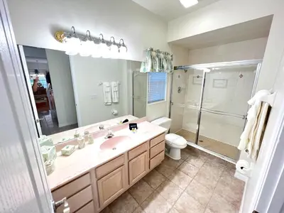 a bathroom with a sink and a shower and a toilet at Mickeys Homestead - Stylish 4BR Lakefront Cottage with Huge South Facing Pool Hot Tub BBQ - 2 miles Disney! in Orlando
