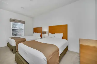 a hotel room with two beds and a television at Regal Oaks Resort Townhouse in Kissimmee