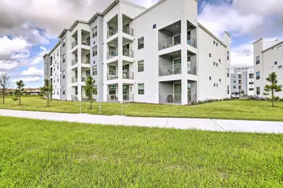 an apartment building with a green lawn in front of it at Kissimmee Condo about 10 Mi to Disney Attractions in Kissimmee