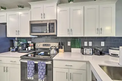 a kitchen with white cabinets and a stove top oven at Kissimmee Condo about 10 Mi to Disney Attractions in Kissimmee