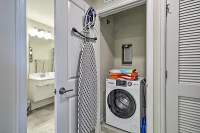 a laundry room with a washing machine and a mirror at Kissimmee Condo about 10 Mi to Disney Attractions in Kissimmee