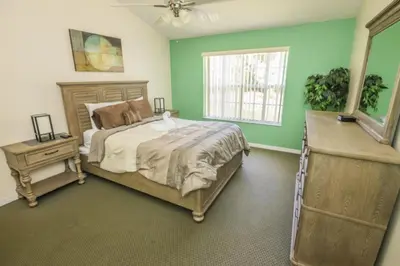 a bedroom with green walls and a bed and a window at 3 Bedroom Resort Condo 8 Miles to Disney Pool Free Parking in Kissimmee