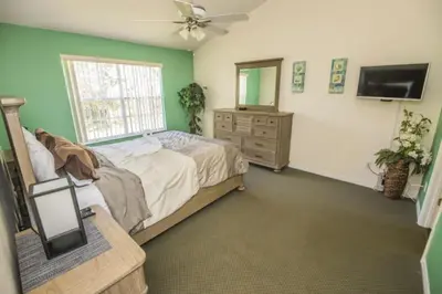 a bedroom with a bed and a dresser and a mirror at 3 Bedroom Resort Condo 8 Miles to Disney Pool Free Parking in Kissimmee