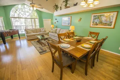 a living room with a wooden table and chairs at 3 Bedroom Resort Condo 8 Miles to Disney Pool Free Parking in Kissimmee