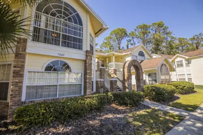 a large yellow house with a gate at 3 Bedroom Resort Condo 8 Miles to Disney Pool Free Parking in Kissimmee