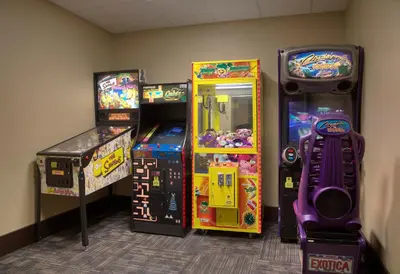 three arcade games are lined up in a room at staySky Suites I-Drive Orlando Near Universal in Orlando