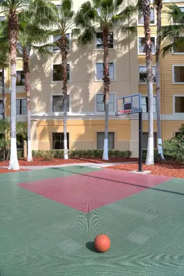 a basketball court in front of a building with palm trees at staySky Suites I-Drive Orlando Near Universal in Orlando