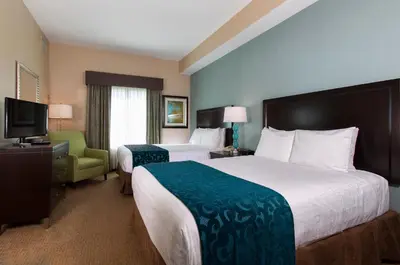 a hotel room with two beds and a television at Hawthorn Extended Stay by Wyndham Orlando in Orlando