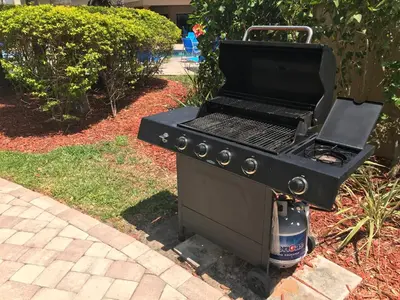 a black barbecue grill sitting in a yard at Hawthorn Extended Stay by Wyndham Orlando in Orlando