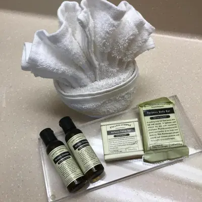 a sink with two bottles of essential oils and a towel at Hawthorn Extended Stay by Wyndham Orlando in Orlando