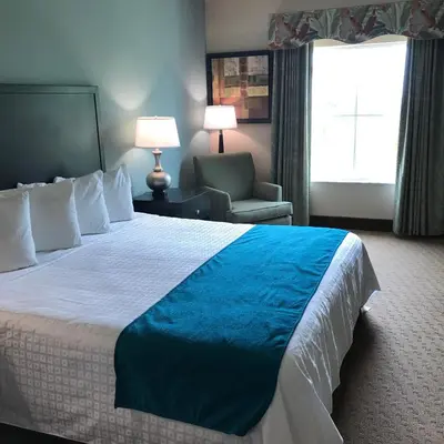 a hotel room with a large bed and a chair at Hawthorn Extended Stay by Wyndham Orlando in Orlando