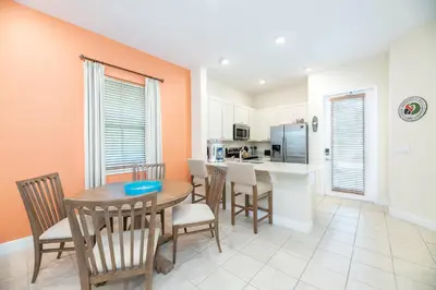 a kitchen and dining room with a table and chairs at Comfortable Cottage Near Disney With Margaritaville Resort & Island H20 Waterpark Access - 3017Sp in Orlando
