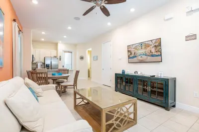 a living room with a couch and a table at Comfortable Cottage Near Disney With Margaritaville Resort & Island H20 Waterpark Access - 3017Sp in Orlando