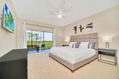 a bedroom with a large bed and a balcony at Spacious 3BR Condo with Pool, near Disney! in Orlando