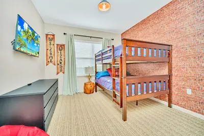a bedroom with a bunk bed and a brick wall at Spacious 3BR Condo with Pool, near Disney! in Orlando