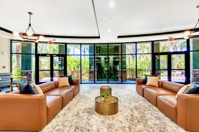 a living room with leather furniture and large windows at Spacious 2BR Condo with Pool , near Disney! in Orlando