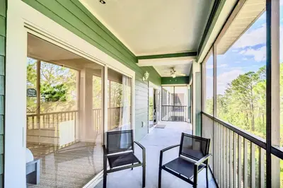 two chairs sitting on a porch with glass windows at Spacious 2BR Condo with Pool , near Disney! in Orlando