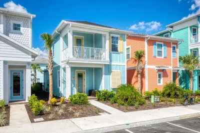 a row of houses with palm trees in front at Dreamy Cottage Near Disney With Margaritaville Resort & Island H20 Waterpark Access - 2944Sr in Orlando