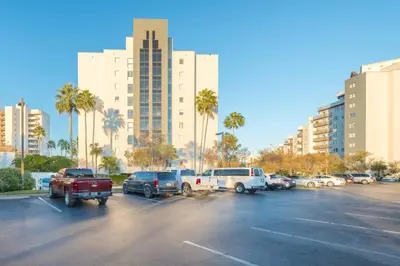 a parking lot with cars and palm trees and buildings at Spacious Studio close to Theme Parks in Orlando