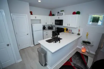 a kitchen with white cabinets and a white counter top at Pet Friendly Modern Zen Studio Retreat with Hot Tub! home in Orlando