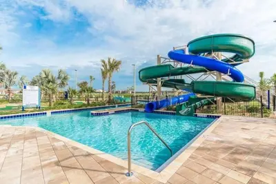 a water slide in a pool at a resort at Storey Lake -6 Bedrooms Luxury home w-pool & spa in Kissimmee
