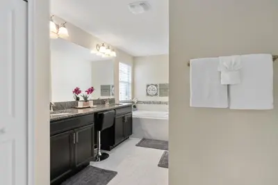 a bathroom with a sink and a bath tub at Storey Lake -6 Bedrooms Luxury home w-pool & spa in Kissimmee