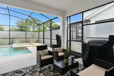a living room with a swimming pool and windows at Storey Lake -6 Bedrooms Luxury home w-pool & spa in Kissimmee
