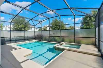 an indoor swimming pool in a glass house at Storey Lake -6 Bedrooms Luxury home w-pool & spa in Kissimmee