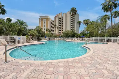 a swimming pool in a resort with buildings in the background at Cozy Condo on International Dr. Near Universal Studios in Orlando