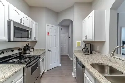 a kitchen with white cabinets and a sink at 2821 Windsor Hills in Orlando