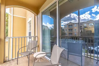 two chairs and a table on a balcony with windows at 2821 Windsor Hills in Orlando