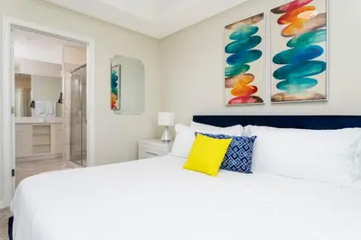 a bedroom with a white bed with a yellow pillow at Family Friendly 2 Bd Close to Disney @ Storey Lake 105 3161 in Kissimmee