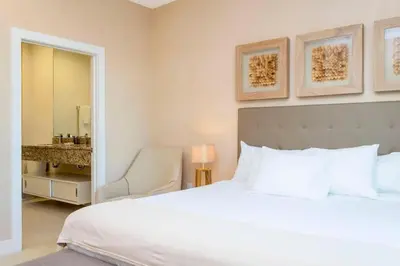 a bedroom with a bed and a chair and a mirror at Stunning 4Bd Close to Disney @ Magic Village 7614 in Orlando