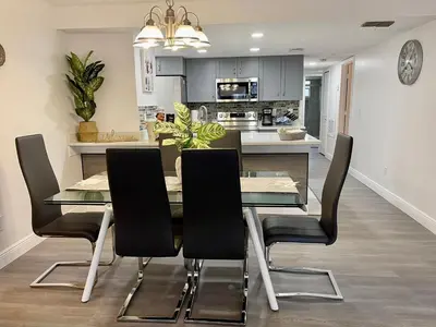 a kitchen and dining room with a table and chairs at Grand Family 3BR Condo Apartment near Disney Parks in Kissimmee