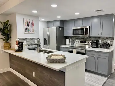a kitchen with gray cabinets and a white counter top at Grand Family 3BR Condo Apartment near Disney Parks in Kissimmee