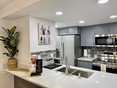 a kitchen with a refrigerator and a counter with a figurine at Grand Family 3BR Condo Apartment near Disney Parks in Kissimmee
