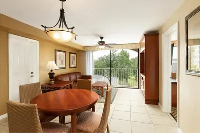a dining room and living room with a table and chairs at Westgate Towers Resort in Orlando