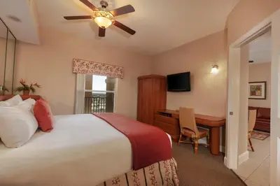 a bedroom with a bed and a desk and a ceiling fan at Westgate Town Center Resort in Orlando