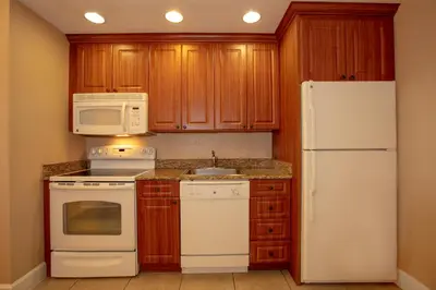 a kitchen with white appliances and wooden cabinets at Westgate Town Center Resort in Orlando
