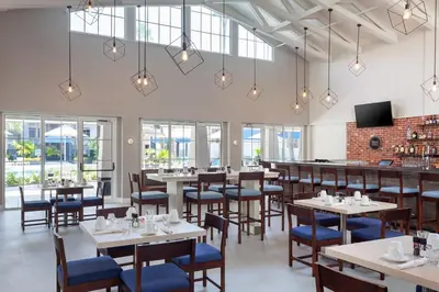 a restaurant with tables and chairs and a bar at Four Points by Sheraton Orlando Convention Center in Orlando